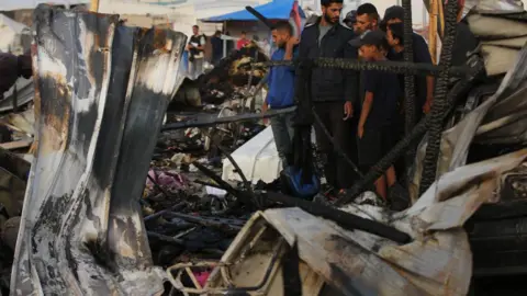 Getty Damaged buildings and people in Rafah, Gaza