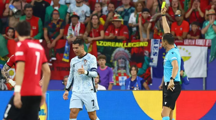 A nervous Cristiano Ronaldo sees the yellow card (Reuters)