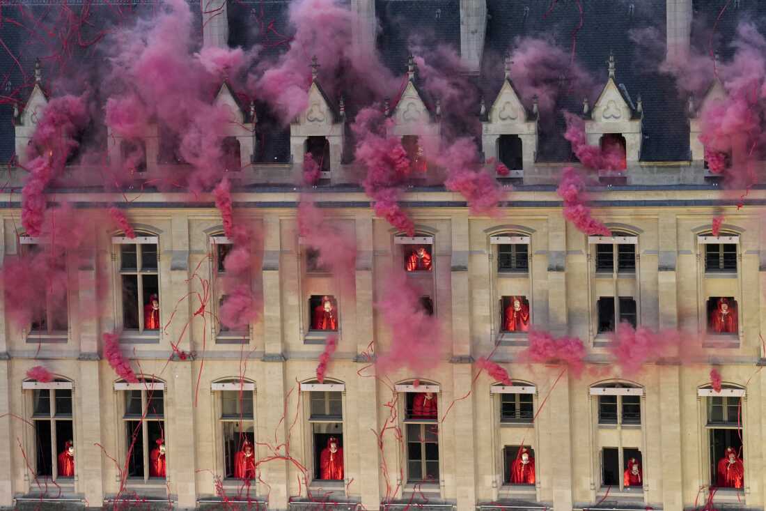 Smoke billows near windows as performers participate during the opening ceremony of the 2024 Summer Olympics, Friday, July 26.