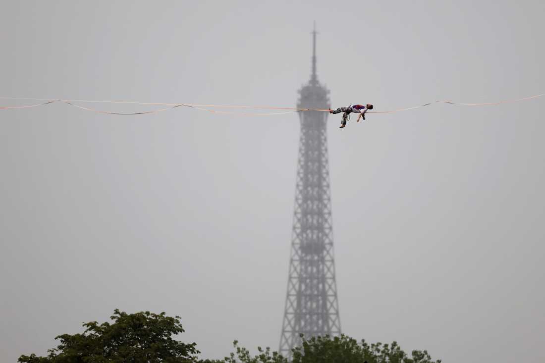 Tightrope walker Nathan Paulin performs on a high rope during the athletes parade on the River Seine near the Supreme Court during the opening ceremony of the Olympic Games Paris 2024 on July 26, 2024 in Paris, France.