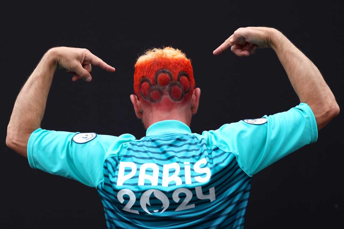 A spectator gestures as the Olympic rings are seen dyed into their hair prior to the opening ceremony of the Olympic Games Paris 2024 on July 26.