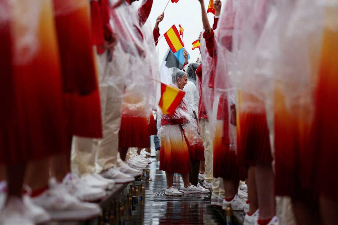 Athletes of Team Spain holding Spanish flags on their delegation boat during the opening ceremony.