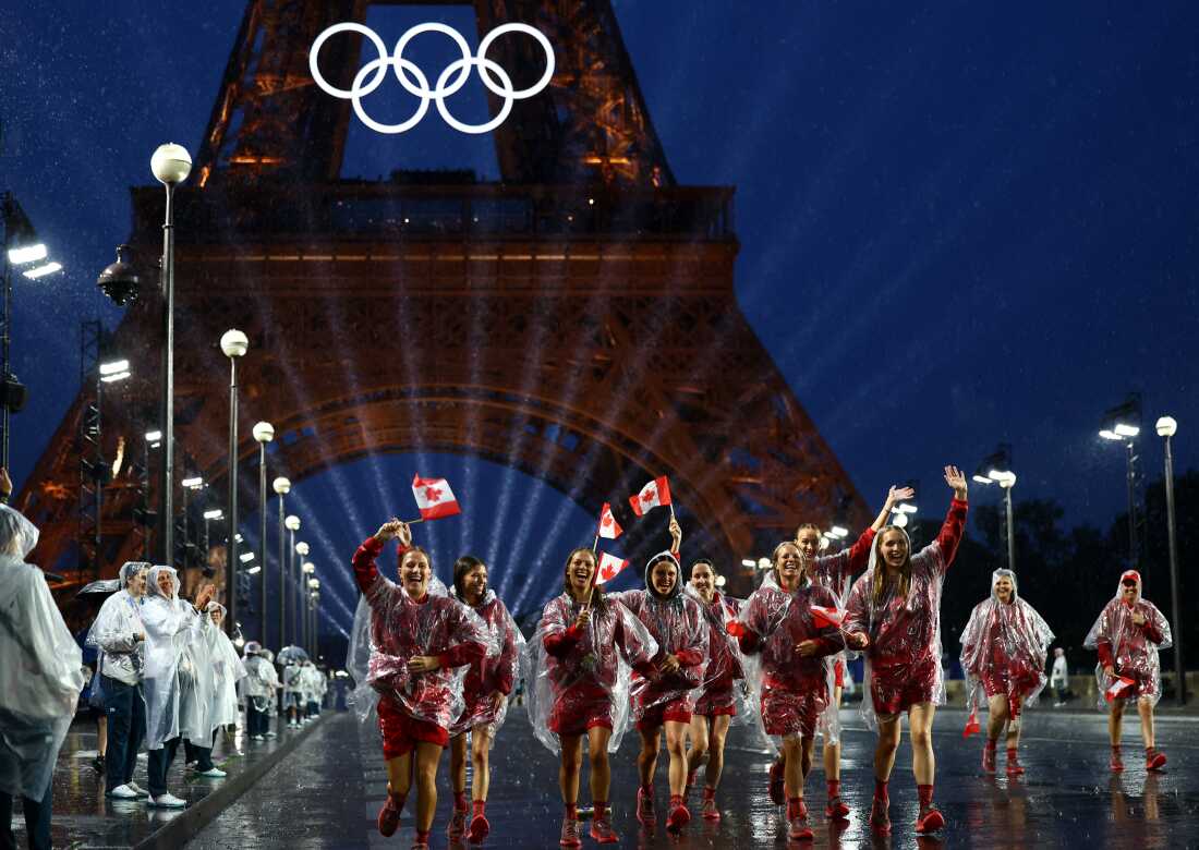 Athletes of Canada wave their flags after arriving at the Trocadero during the opening ceremony.