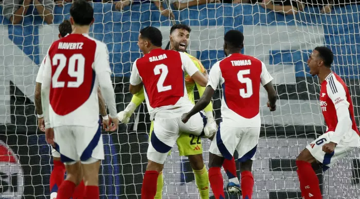 Arsenal players hug David Raya (Reuters)