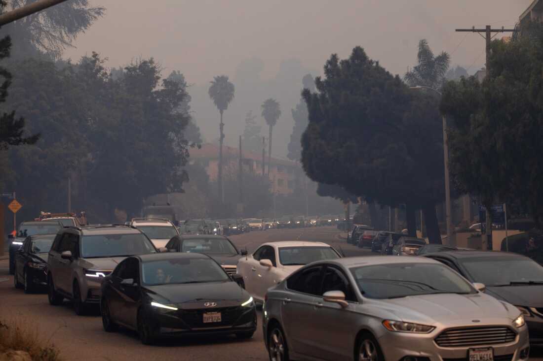 People evacuate on Sunset Boulevard from the Palisades Fire on Jan. 7, 2025 in the Pacific Palisades neighborhood of Los Angeles, Calif.