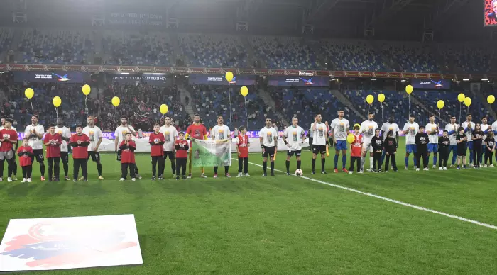 Hapoel Haifa and Ashdod players take the field with yellow balloons (Omari Stein)